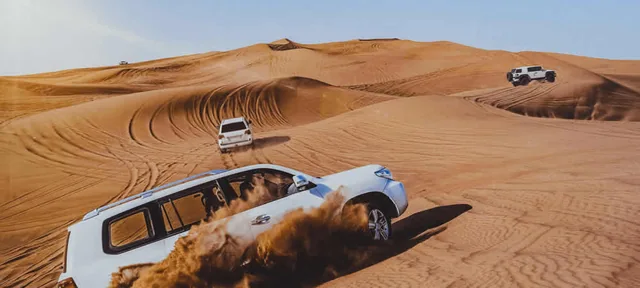 4x4 vehicles travelling through sand dunes