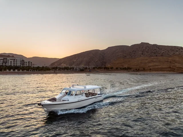 A motorboat on the Muscat coast in evening light