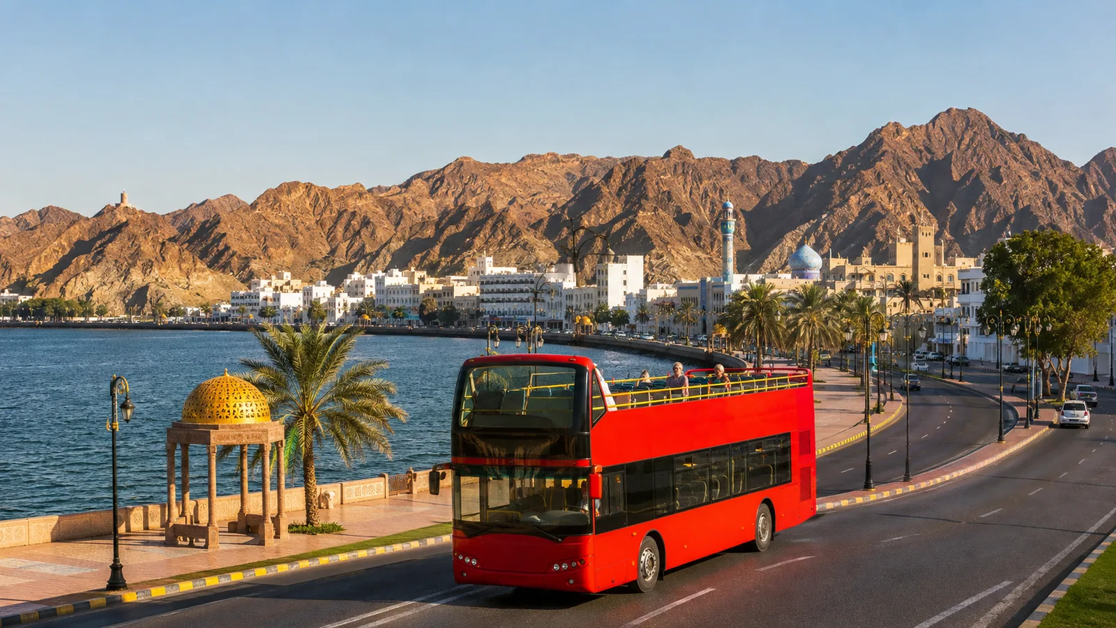 An open-top sightseeing bus beside the Muscat waterfront