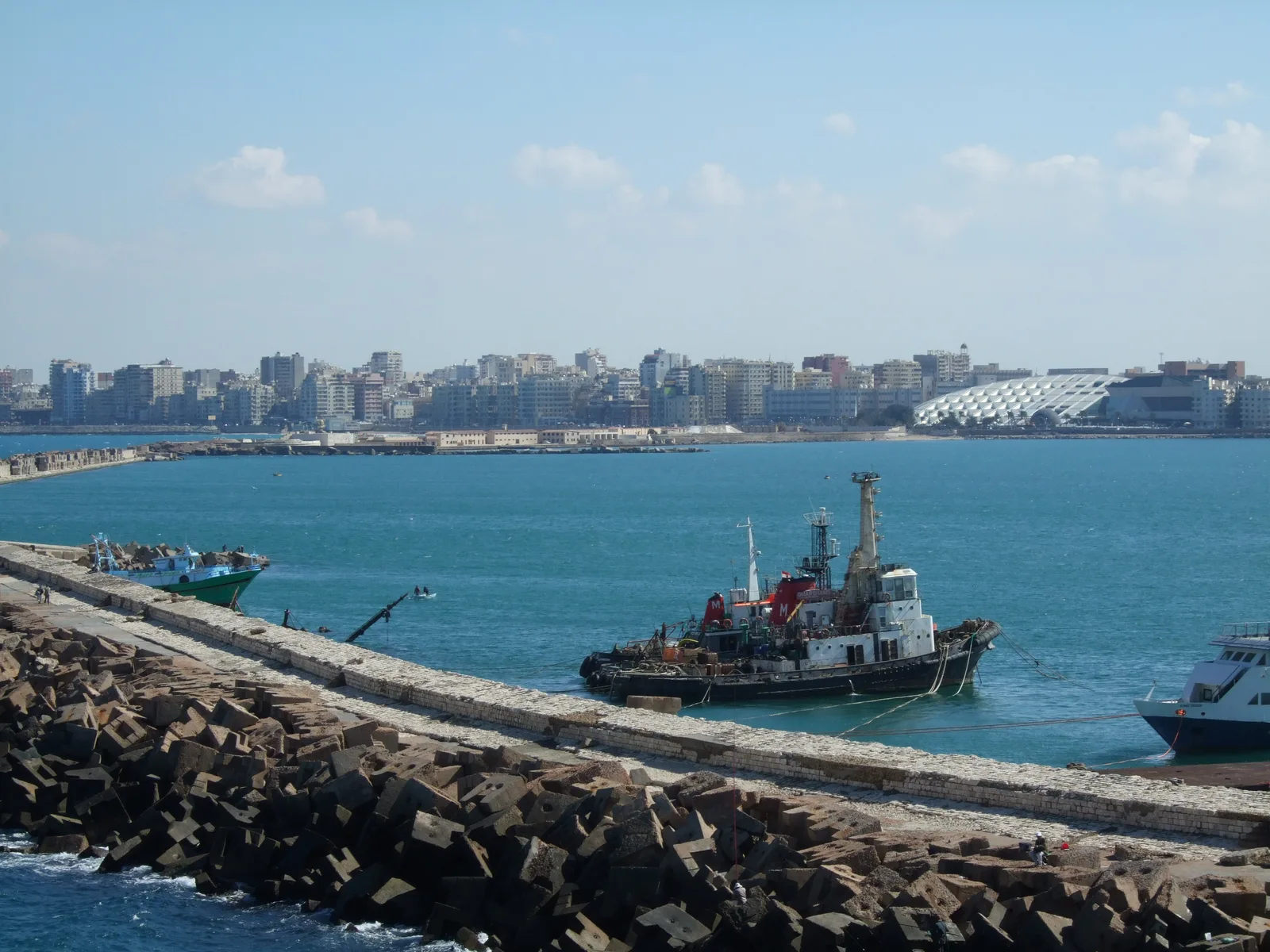 Alexandria harbour and waterfront viewed from Qaitbay, with boats in the foreground