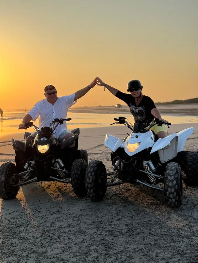 Quad bikes lined up on the sand