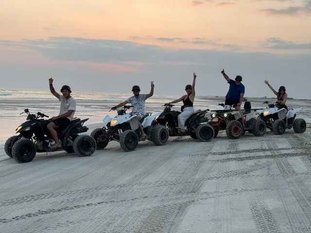 Riders and quad bikes on a sandy beach