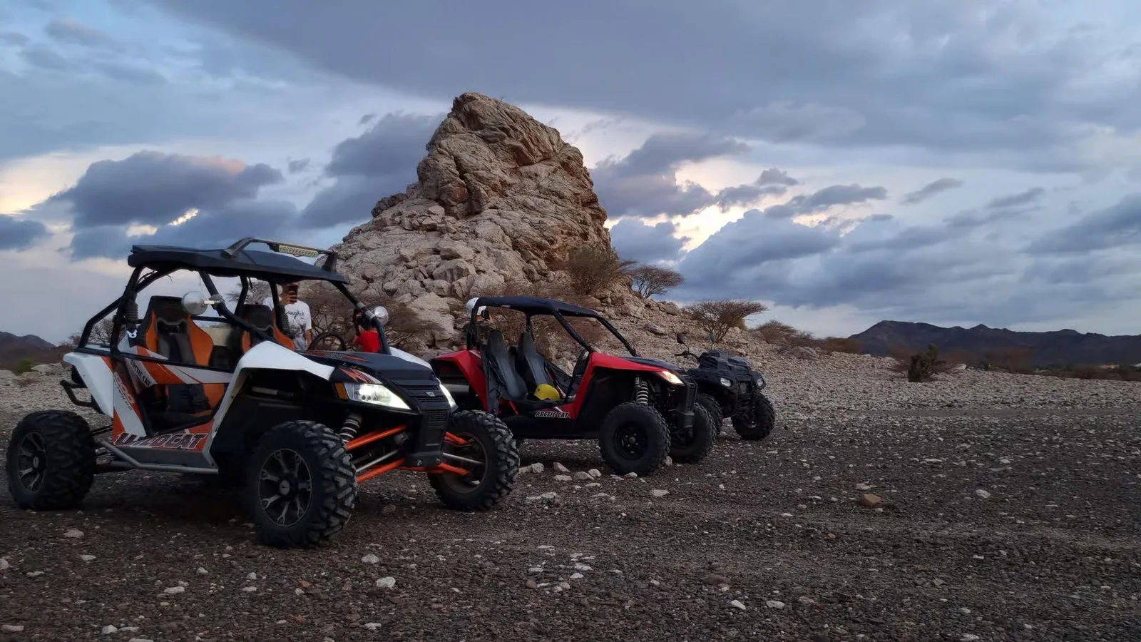 UTVs parked beside a rocky trail