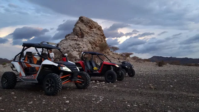 UTVs parked beside a rocky trail