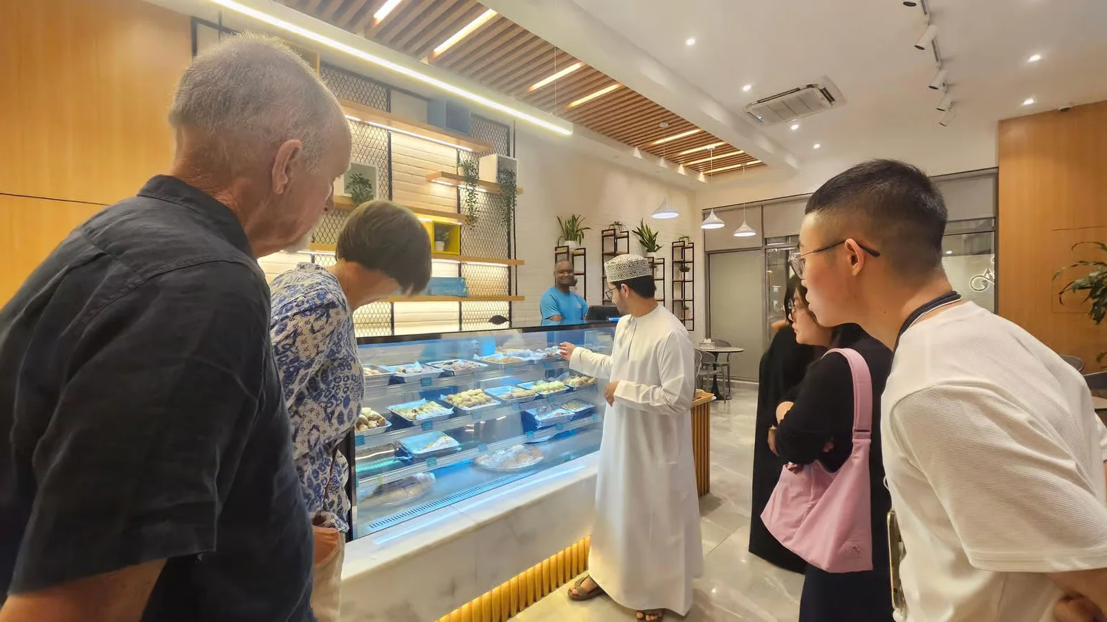 Visitors looking at food displayed in a shop